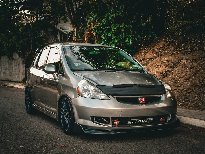 プエルトリコの道路に停車する、ハリーが以前所有していたグレーのターボGD3 Honda Fit。フロントからインタークーラーが見える。