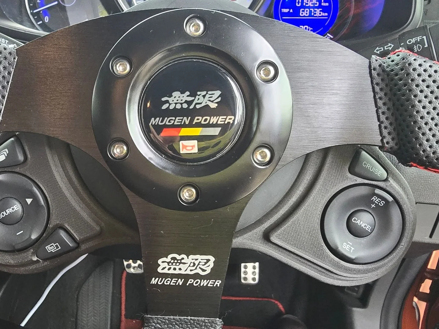 無限ステアリングの左右に純正オーディオとクルーズコントロールのスイッチを移設したHonda Fitの運転席。
