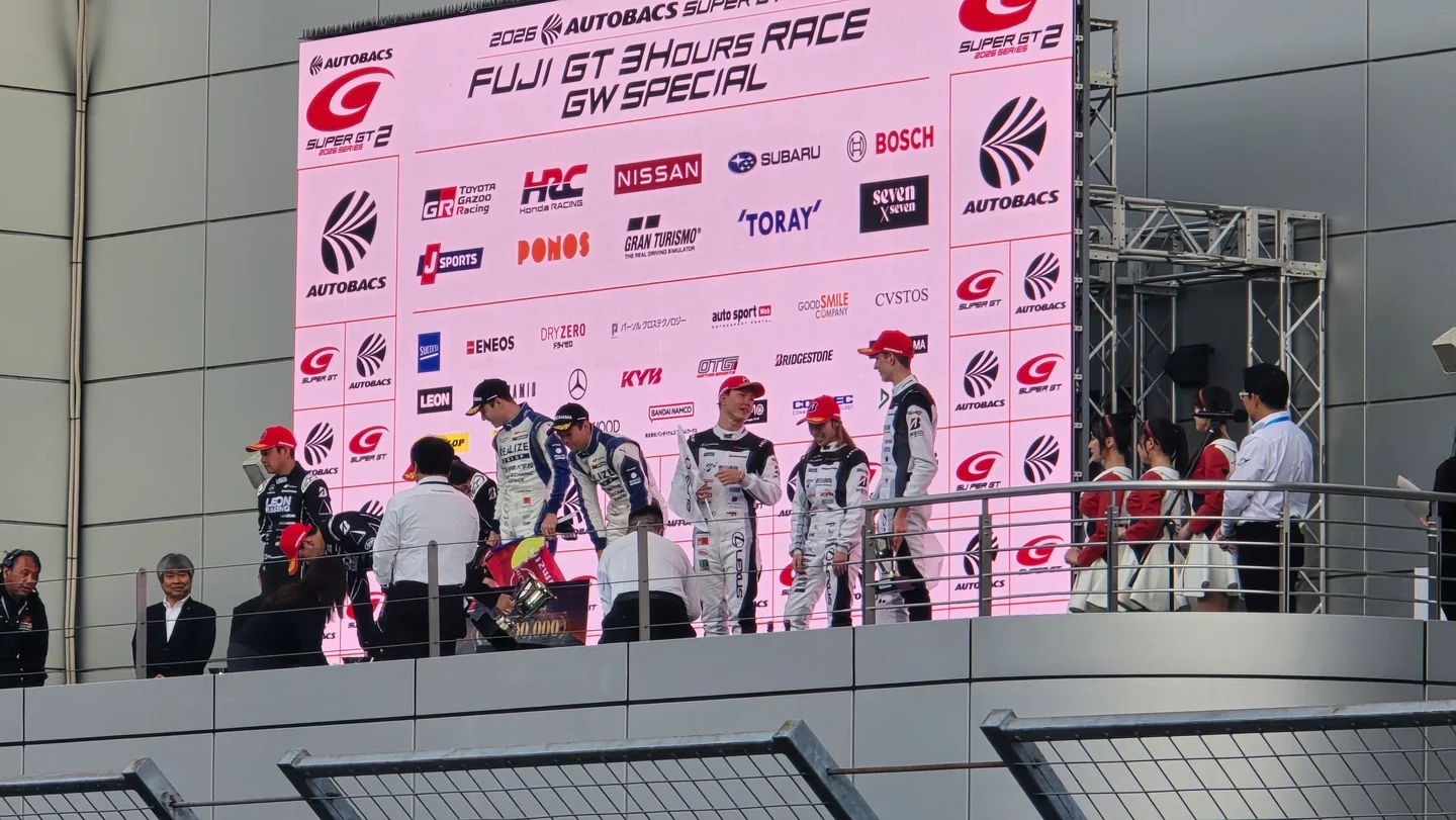 富士スピードウェイのGT300表彰台で、No.56、No.65、No.31のドライバーたちが祝う。