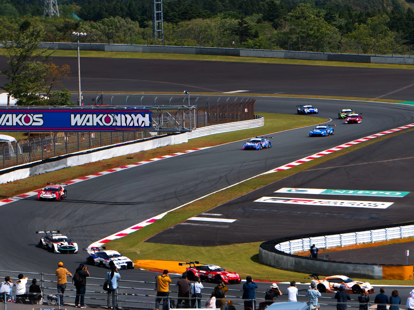 3時間レース中、富士スピードウェイのコーナーをGT500とGT300の車両集団が走る。