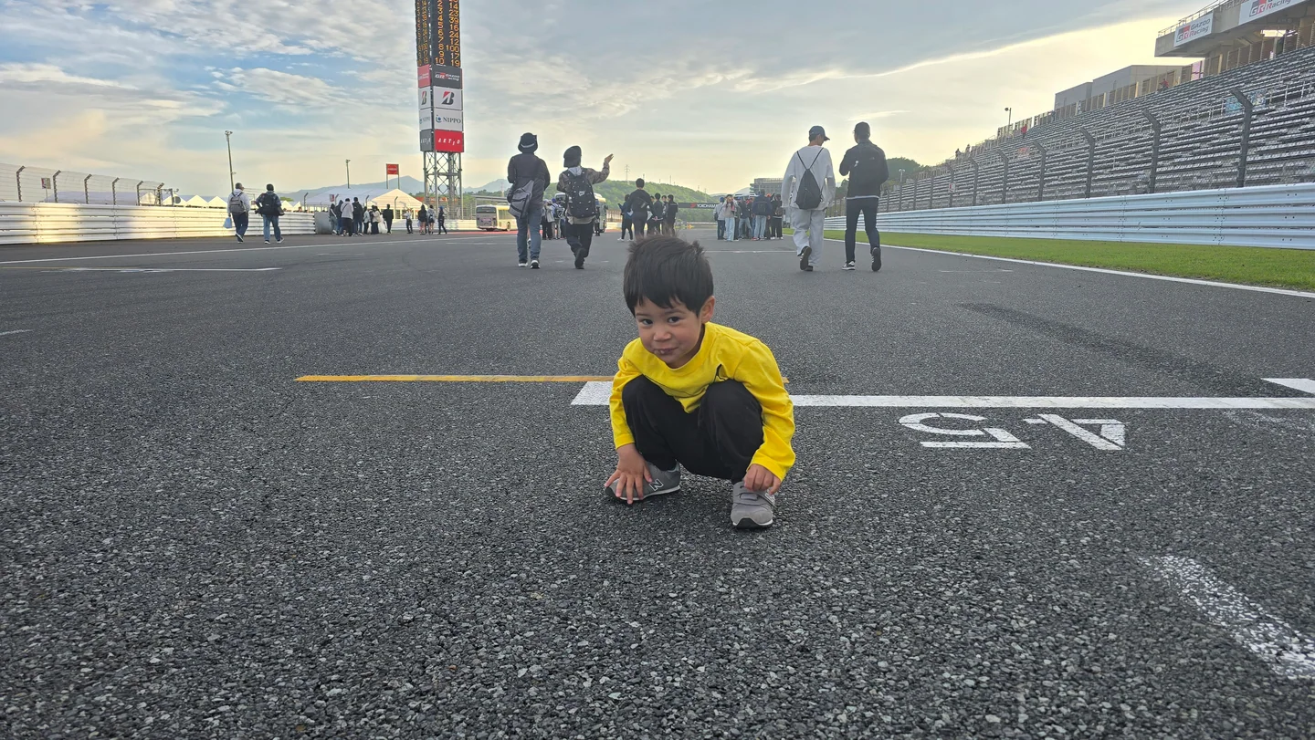 レース後、富士スピードウェイのスタート/フィニッシュストレートに描かれたグリッド位置でしゃがむ末の息子。