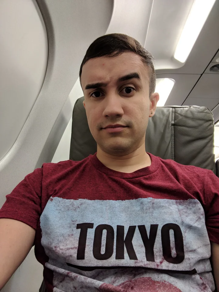 TOKYOと書かれたシャツを着て、一人で飛行機に乗るハリー。