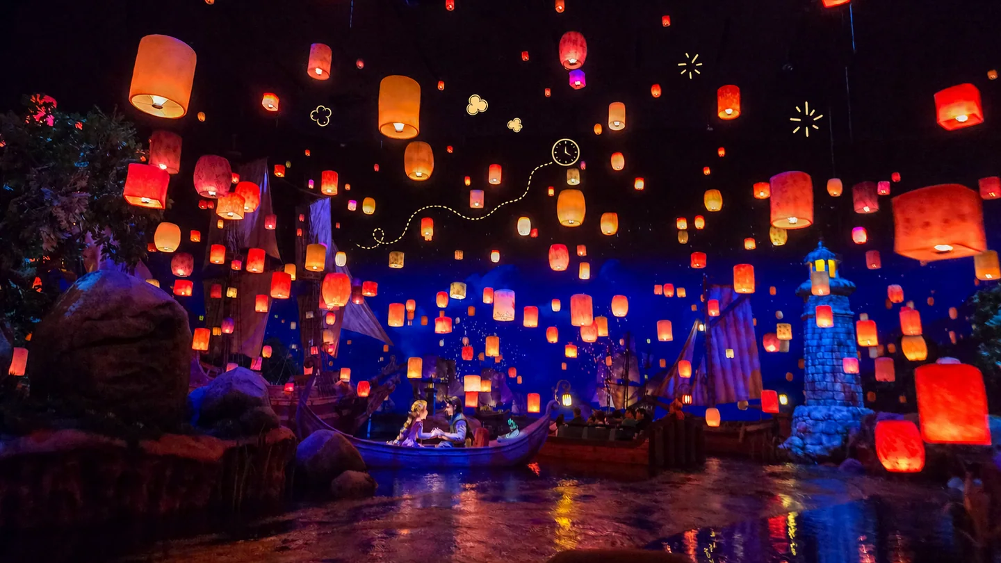 Glowing lanterns fill the dark sky above Rapunzel’s Lantern Festival, with small hand-drawn queue, clock, sparkle, and popcorn doodles.